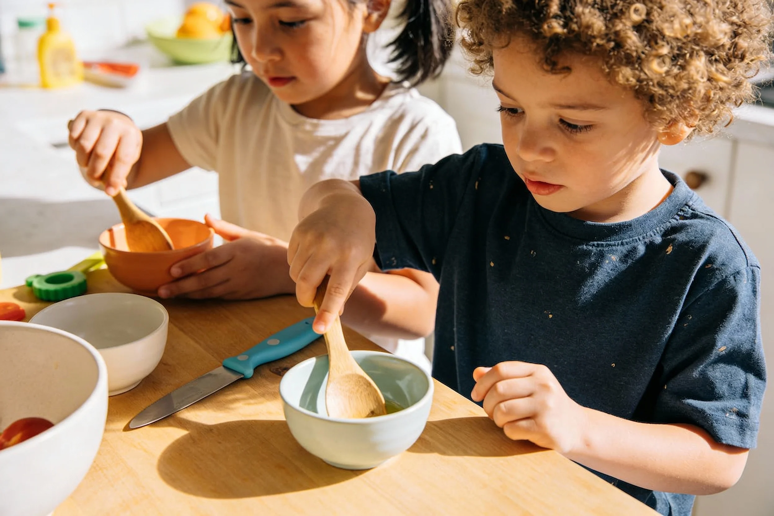 Children using Montessori cooking tools