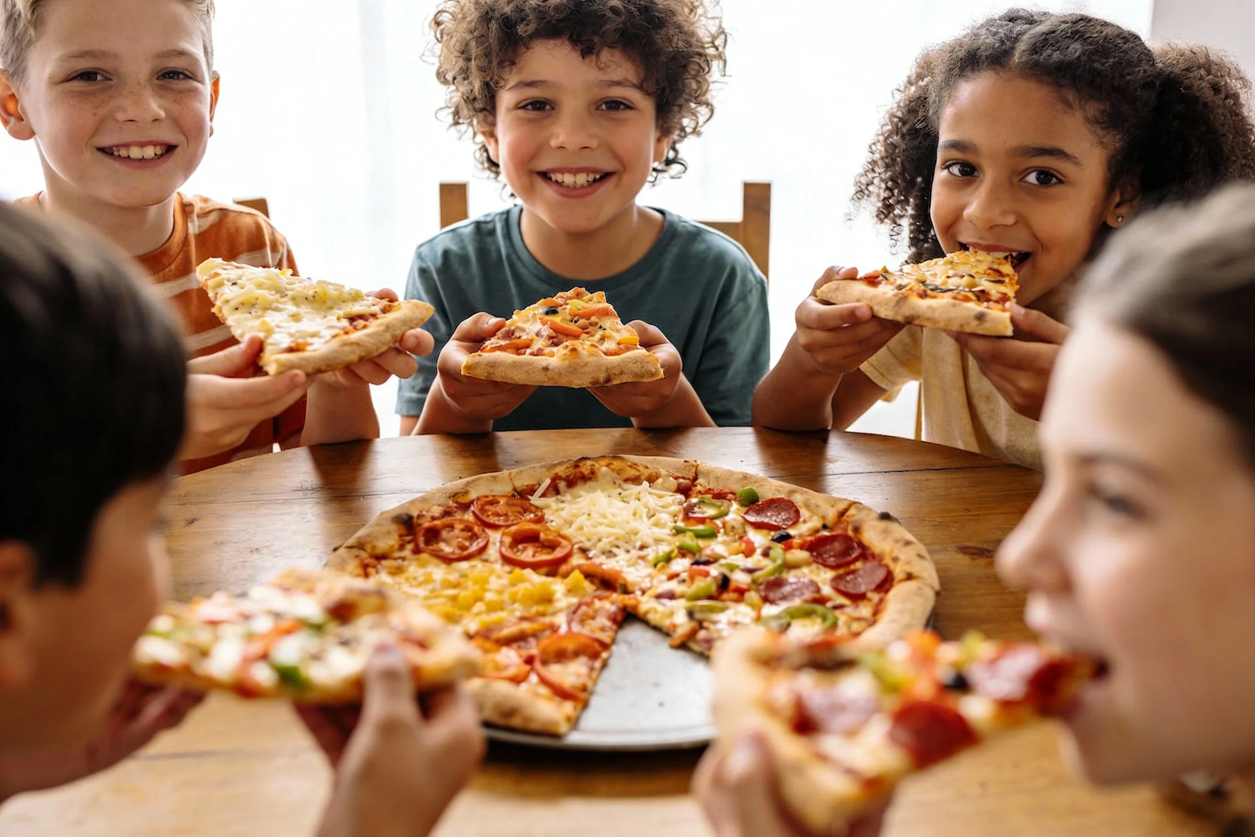 Kids enjoying their homemade pizzas